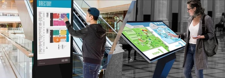 Two people interacting with interactive digital displays in a modern indoor space, viewing maps and directory information